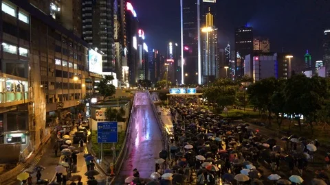 Chanting 'Five demands not one less' under neon lights of Central in the rain Stock Footage 116321464