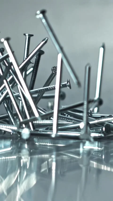 Chaotic arrangement of nails reflecting light and texture Filmed on a high-speed Stock Footage 335396328