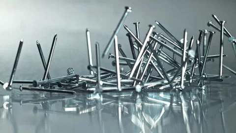 Chaotic arrangement of nails reflecting light and texture Filmed on a high-speed Stock Footage 335413726