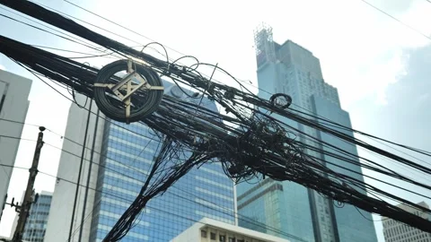 Chaotic Overhead Power Cables Cross Modern Skyscrapers, Dense Asian City Street Stock Footage 345370705