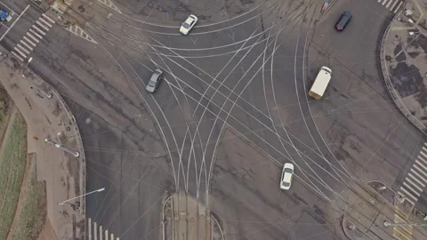 Chaotic road intersection aerial view with tram tracks and moving cars Stock Footage 303084026