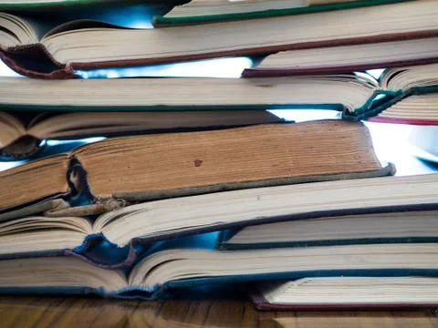 Chaotic stack of old books background, selective focus. Stock Photos