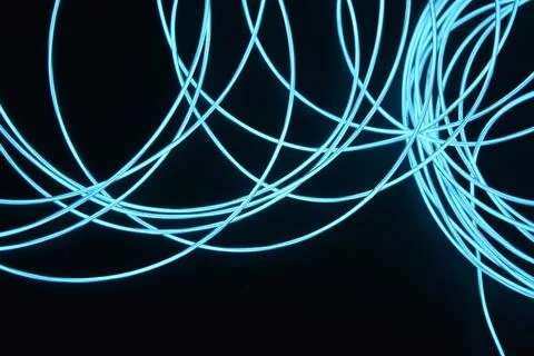 Chaotically celestial, light blue, neon harness, illuminated wire, thin wire. Stock Photos