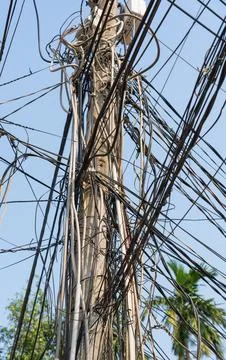Chaotically connected and stretched wires on an electric pole in Asia Stock Photos