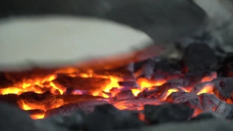 Chapati baking on fire close-up with sizzling ingredients on hot coals Video stock 310942377