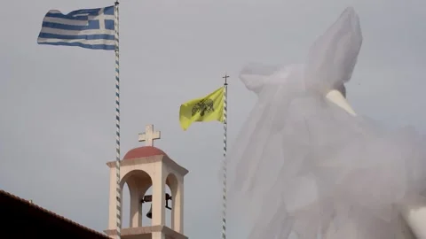 Chapel in Greece with flags waving and white cloth on pole Stock Footage 341138576