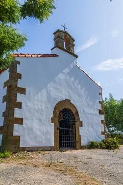 Chapel with whitewashed facade, stone quoins and small belfry topped with cross Fotos Stock