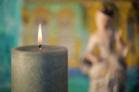 Character is emphasized by the blurring areas. In foreground a burning candle Stock Photos