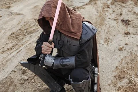 Character in Star Wars sits and rests in the sand Stock Photos