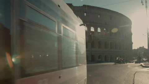 Characteristic Rome tram passes in front of the coliseum at sunset Stock Footage