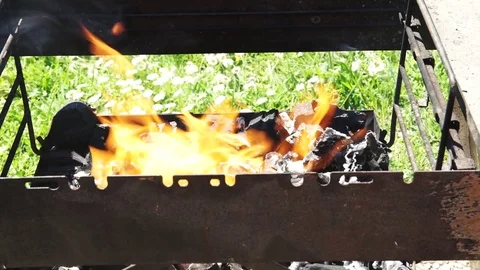 Charcoal burning in the grill getting ready for the summer barbecue, 4K  Vidéo 75556736