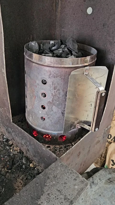 Charcoal chimney starter igniting coals for barbecue Stock Footage 308823765