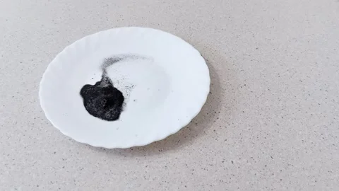 Charcoal Meets Peroxide: Bubbling Breakdown on a White Plate 스톡 동영상 318579076
