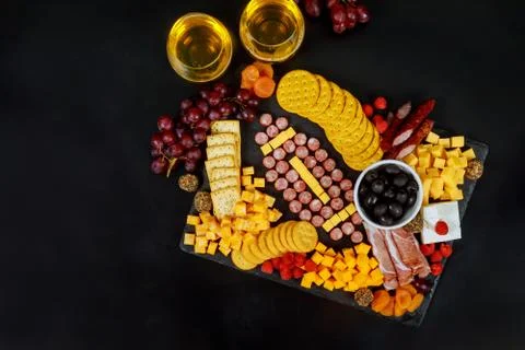 Charcuterie board with cheese, grape, raspberry, crackers and drink. Stock Photos