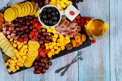 Charcuterie board with cheese, olives, fruits, prosciutto and wine on wooden  Stock Photos