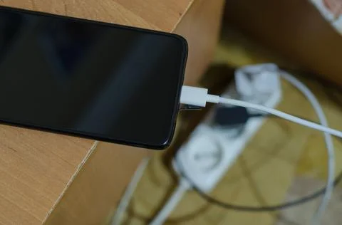 The charger is connected to the smartphone. Stock Photos