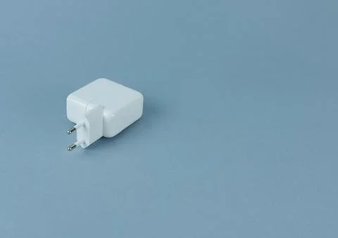 A charger for a tablet on a blue background. Stock Photos