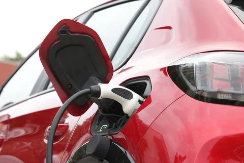 Charging cable and spot for a red car,electric vehicle. Stock Photos
