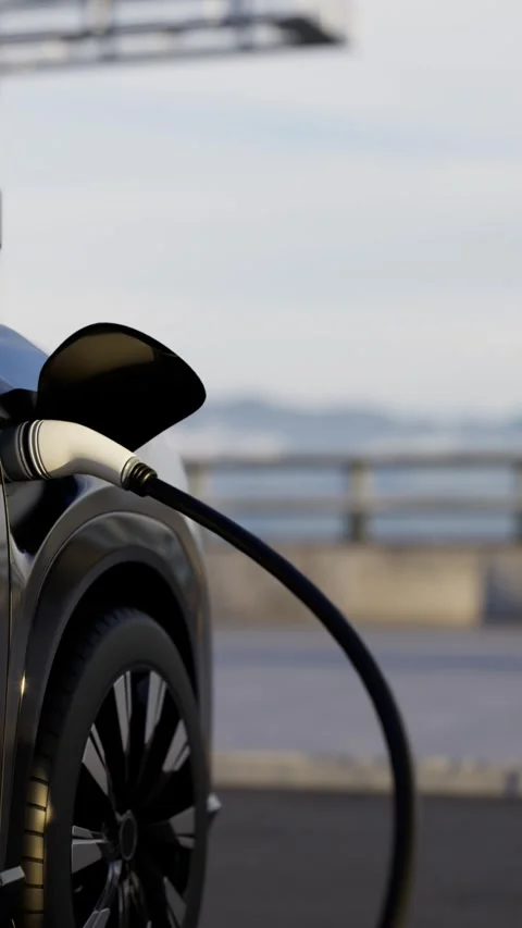 Charging cable plugged into a electric vehicle at an outdoor charging station Vidéo 332301896