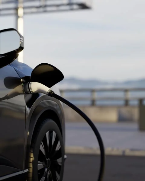 Charging cable plugged into a electric vehicle at an outdoor charging station Video stock 332301898