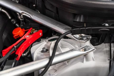 Charging car battery with electricity using connecting cables. Stock Photos