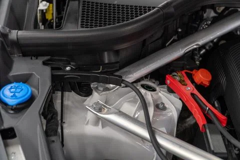 Charging car battery with electricity using connecting cables. Stock Photos