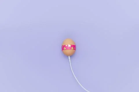 Charging Easter egg with cable. Loading simple background Stock Photos