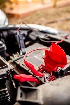 Charging an empty car accumulator with battery charger Stock Photos