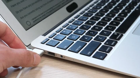 Charging a Laptop Computer by Plugging a Magnetic Cable Stock Footage 90011283