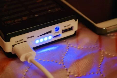 Charging a mobile phone using a power bank Stock Photos