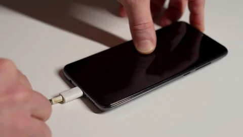 Charging phone with broken charging cable, close-up. Hand holding frayed ch.. Stock Footage 296363164