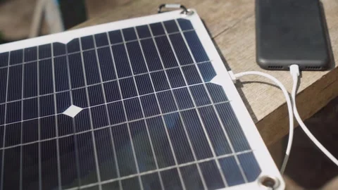Charging phone with a portable solar panel. Stock Footage 243293390