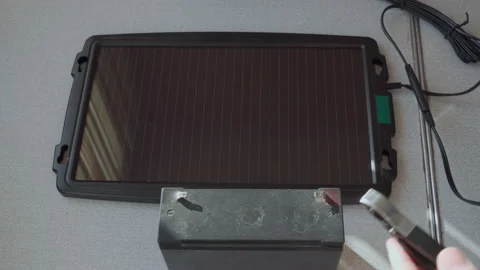 Charging a small battery with a solar panel. Video stock 228824264