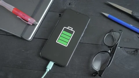 Charging a smartphone lying on the table Stock Footage 201684977