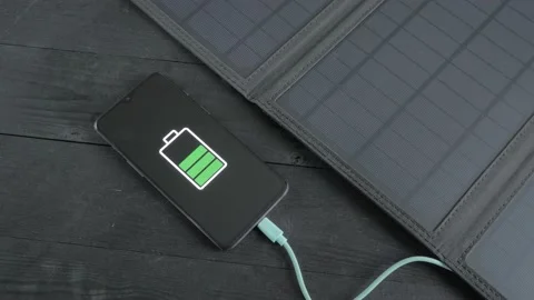 Charging a smartphone with a portable solar panel Stock Footage 201684948