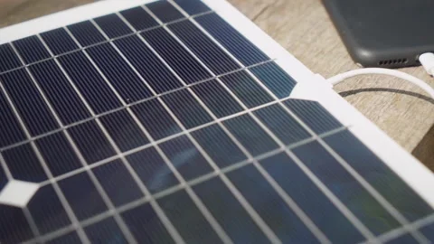 Charging a smartphone with a portable solar panel. camping. Stock Footage 242166728
