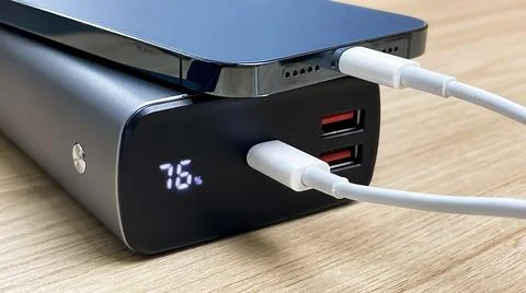 Charging a smartphone using an external battery via a USB cable. Fotos de archivo
