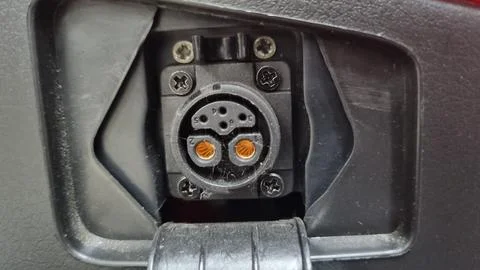 Charging socket for a charging plug under the seat of an electric motorcycle. Stock Photos