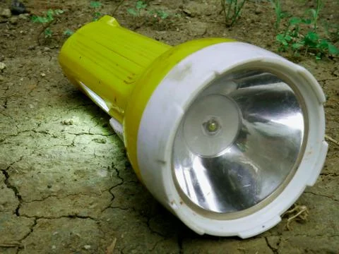 Charging torch liming light presented on soil field, Technology object image. Fotos de archivo