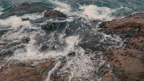 Charging waves on cliffs covered with mussels Видео 136575511