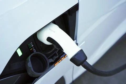 Charging a white electric car close-up.Altrernative eco energy fuel.Power sup Stock Photos