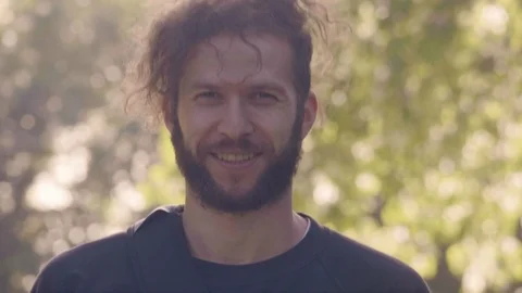 Charismatic bearded man looking in camera, straightens disheveled hair and makes Stock Footage 98774239