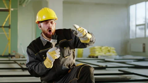 Charismatic man constructor worker at construction site using a painting brush Stock Footage 199452706