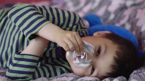 Charismatic multi-ethnic boy playing with finger spinner and applies it to the Stock Footage 77260097