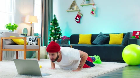 Charismatic young man have time for workout doing push-ups while watching a Stock Footage 160804993