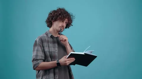 The charismatic young man, thoughtfully making notes, thinks, and when an idea Stock-Footage 153084487