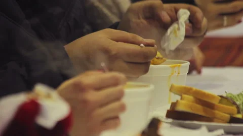 Charity event. Helping homeless. Poor and hungry people eating hot tasty soup Stock Footage