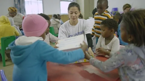 Charity worker playing with children from a poor African community - EDITORIAL Stock Footage 77591081