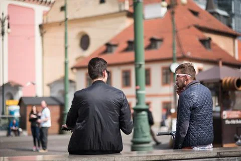 The Charles Bridge is crowded of people, while tourists enjoy walking interac Stock Photos