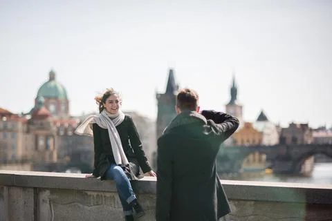 The Charles Bridge is crowded of people, while tourists enjoy walking interac Stock Photos